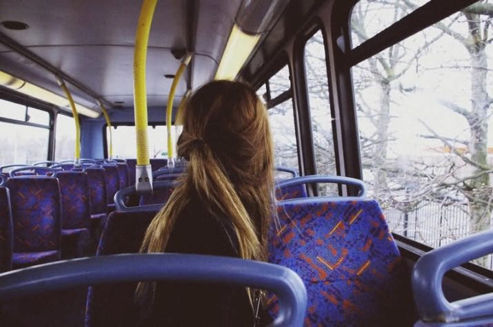 Девушка в автобусе поправляет прическу